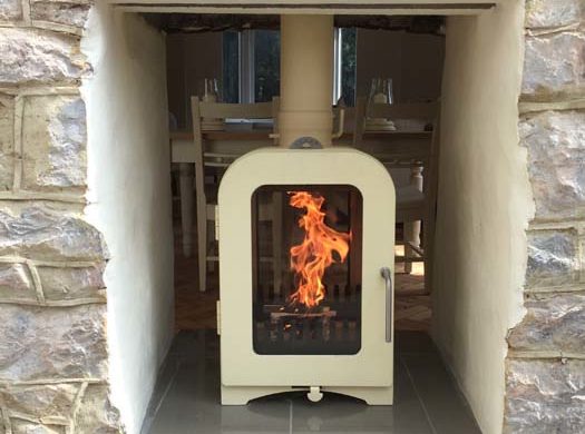 modern wood burner installed into stone fireplace