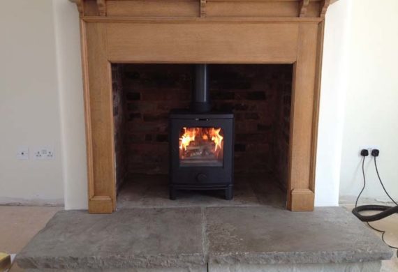 new log burner in wooden surround fireplace