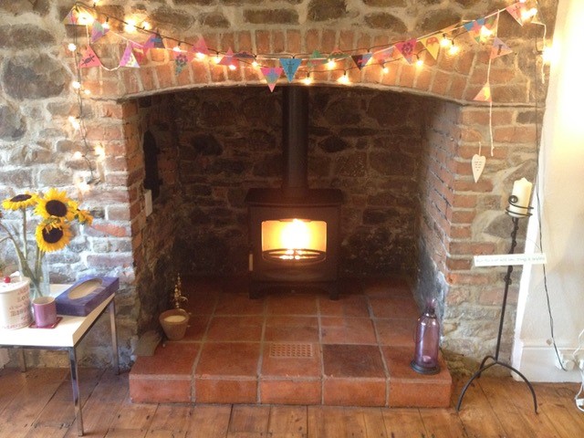 new log burner in brick surround fireplace