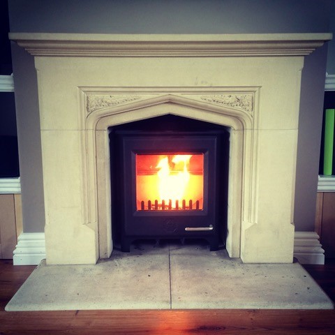 wood burning stove fitted into a marble fireplace